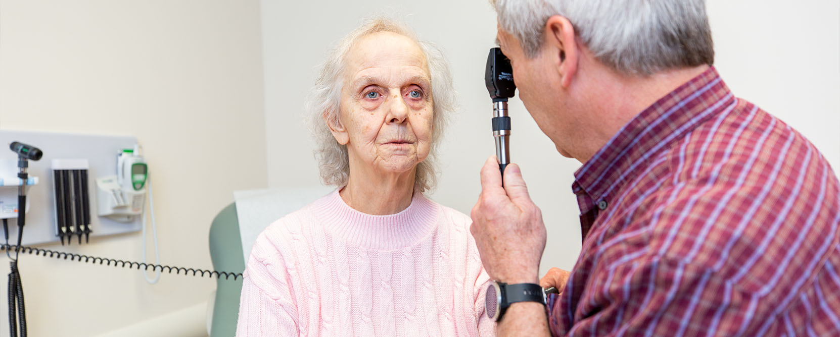 Older adult patient has her eyesight checked by a doctor
